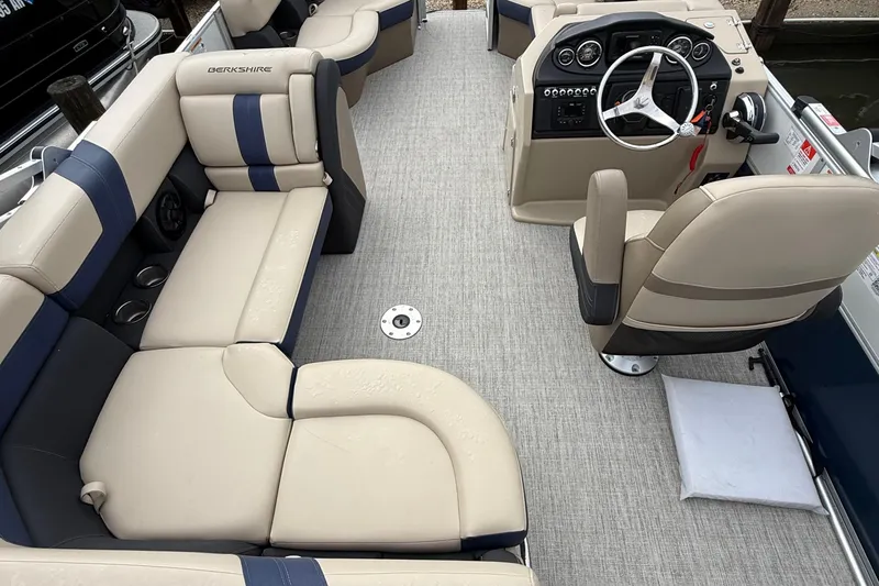 Slide: The Image of 2025 Berkshire 24RFC CTS 2.75 pontoon boat interior with beige and blue seating, steering console. - 6