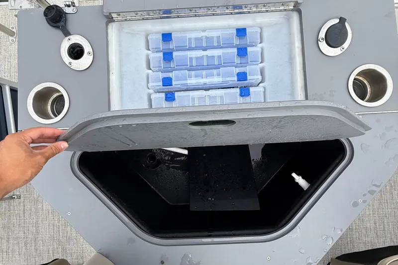 Slide: The Image of Open storage compartment on 2025 Berkshire 24RFC CTS 2.75 boat with tackle boxes. - 7