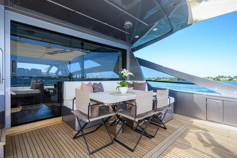 Slide: The Image of Luxurious 2022 Pershing 9X yacht deck with white seating and scenic waterfront view. - 17