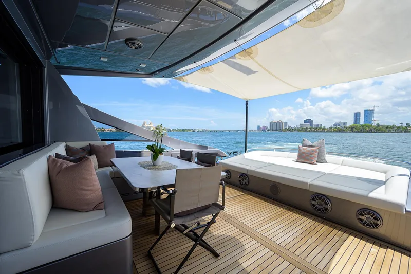 Slide: The Image of Luxurious 2022 Pershing 9X yacht with elegant outdoor seating and scenic waterfront view. - 18