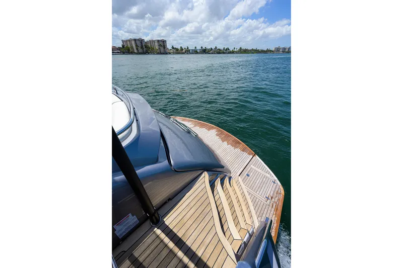 Slide: The Image of Luxurious 2022 Pershing 9X yacht with spacious sunbed on deck, cruising in clear blue waters. - 22