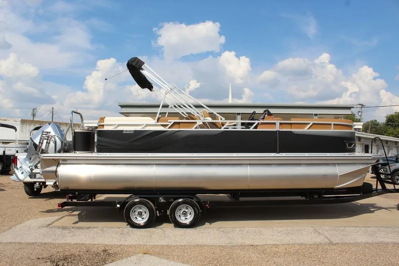 Slide: The Image of 2026 Avalon Venture 85 Quad Lounger 23 FT pontoon boat on trailer, under blue sky. - 4