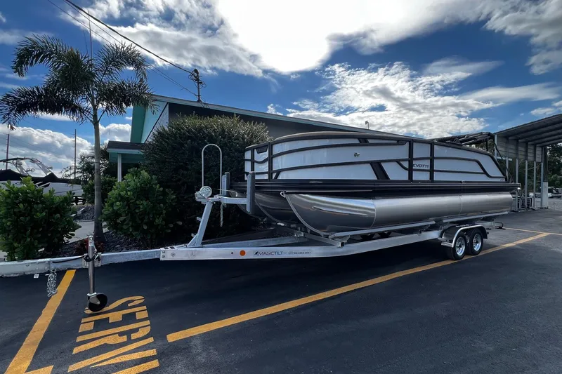 Slide: The Image of 2026 Evotti 523CS pontoon boat on trailer under cloudy sky. - 1