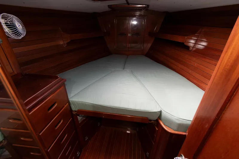 Slide: The Image of 1979 Hinckley 43 Sloop cabin interior with wooden finish and cozy bed. - 15