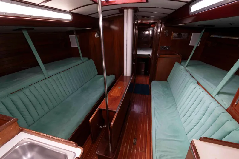 Slide: The Image of 1979 Hinckley 43 Sloop docked at a serene marina with clear skies. - 10