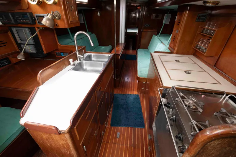 Slide: The Image of Cockpit of 1979 Hinckley 43 Sloop with wooden helm, docked by a serene lake. - 11