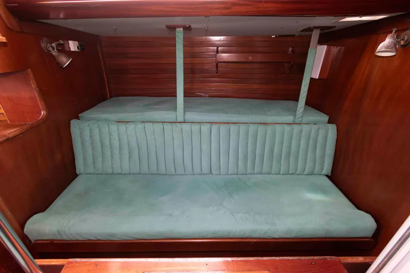 Slide: The Image of Interior of 1979 Hinckley 43 Sloop with green seating and wooden finishes. - 13