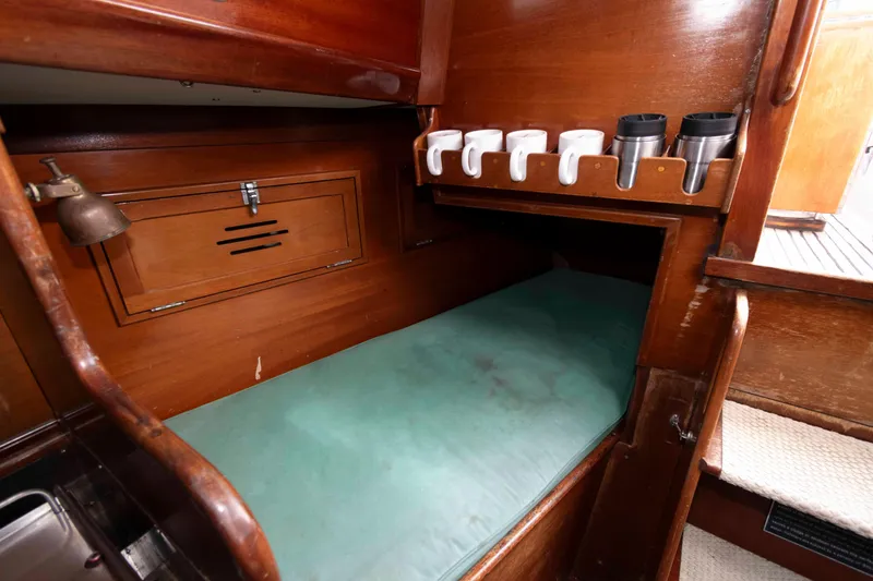 Slide: The Image of Interior of 1979 Hinckley 43 Sloop with teal cushions and wooden cabinetry. - 17