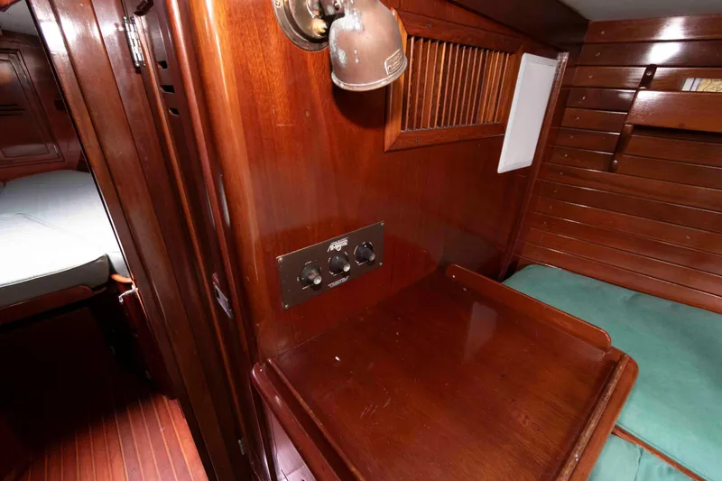 Slide: The Image of Interior cabin of 1979 Hinckley 43 Sloop with wooden finish and green mattress. - 19