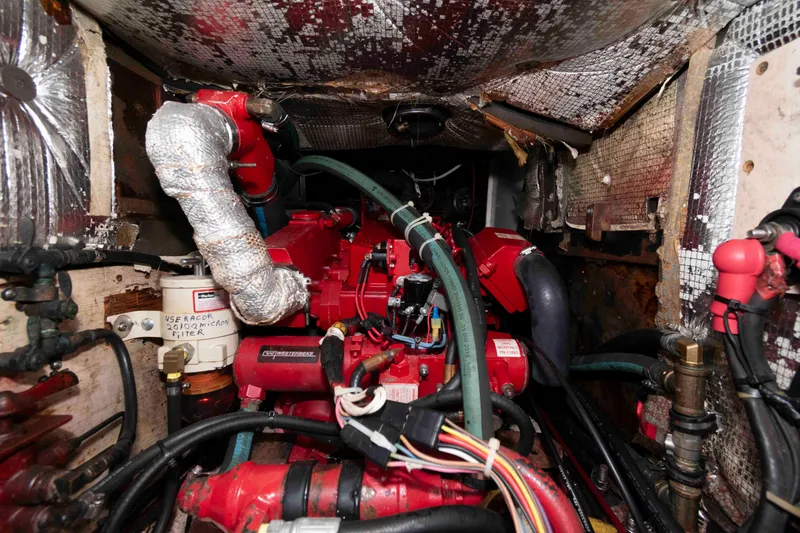 Slide: The Image of Engine compartment of a 1979 Hinckley 43 Sloop, featuring red machinery and insulated pipes. - 25
