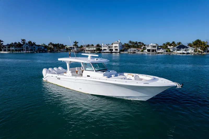 Slide: The Image of 2026 HCB 48 Campeon boat on calm water with coastal homes in the background. - 2