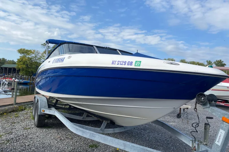 Slide: The Image of 2005 Yamaha Boats SX230 on trailer by lakeside under blue sky. - 3