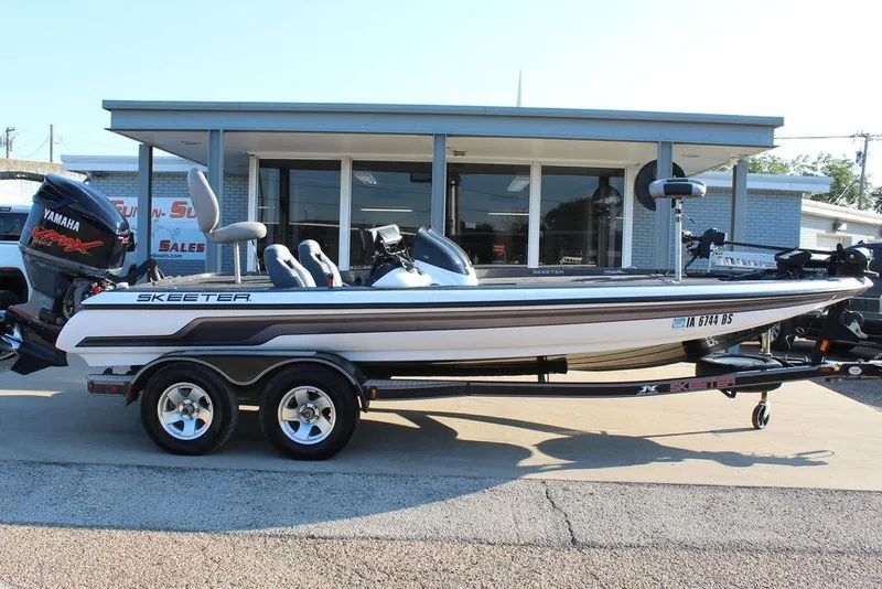 Slide: The Image of 2011 Skeeter ZX225 bass boat with Yamaha motor, parked on a trailer outside a dealership. - 3