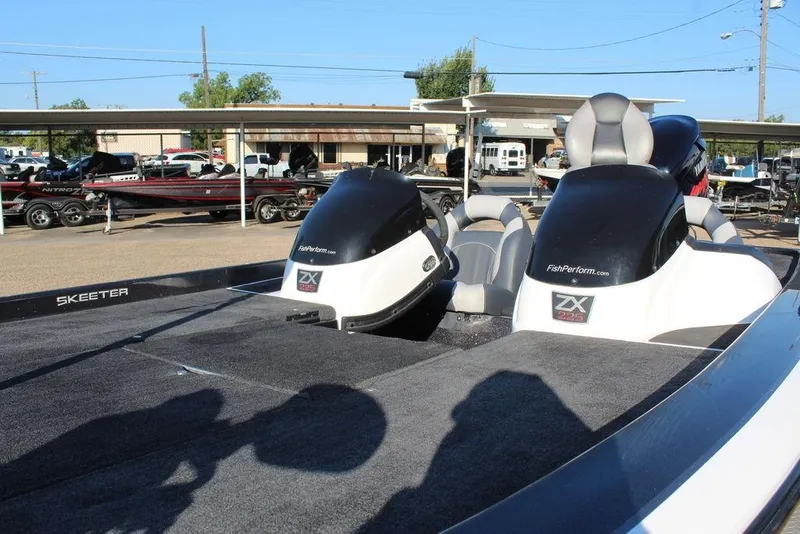 Slide: The Image of 2011 Skeeter ZX225 boat with dual seats and outboard motors in a parking area. - 9