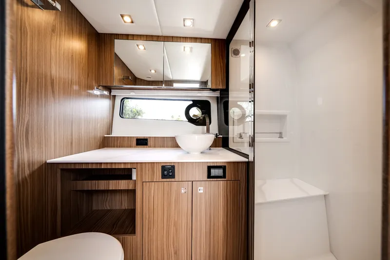Slide: The Image of Interior of the 2026 Cruisers Yachts 50 GLS with wood paneling and modern sink. - 48