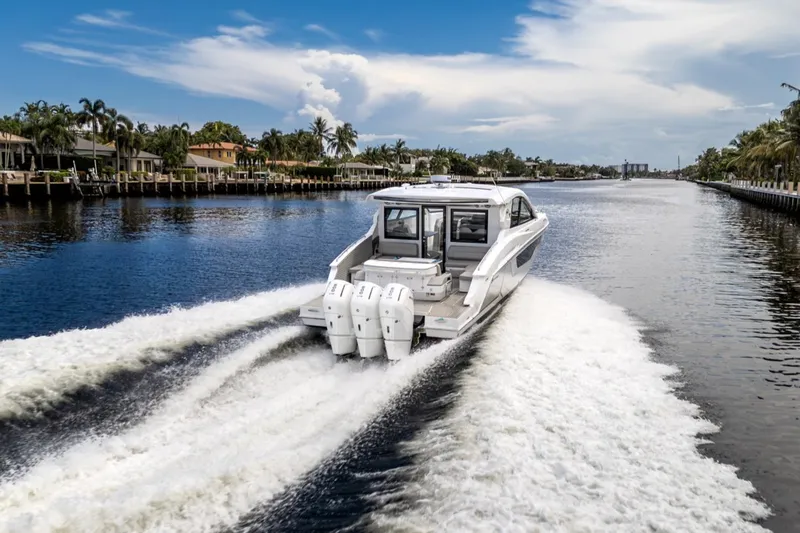 Slide: The Image of A luxury motor yacht cruises on a wide canal, surrounded by palm trees and houses. - 14