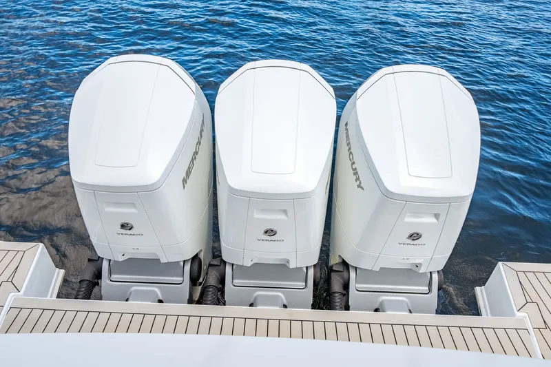 Slide: The Image of Three Mercury outboard engines on a Cruisers Yachts 50 GLS, resting on calm water. - 18