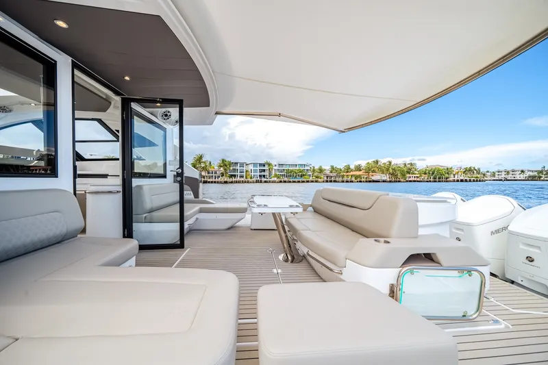 Slide: The Image of The image shows the luxurious deck of a 2026 Cruisers Yachts 50 GLS with elegant seating. - 25