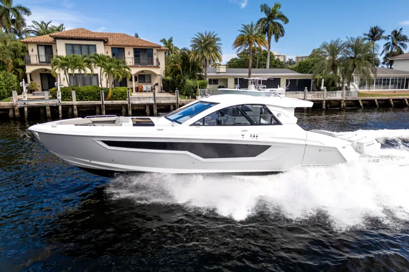 Slide: The Image of 2026 Cruisers Yachts 50 GLS on the water in front of luxury homes. - 13