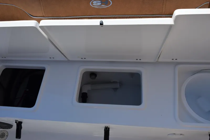 Slide: The Image of 2026 Sea Hunt Ultra 229 boat storage compartments and seating area. - 19