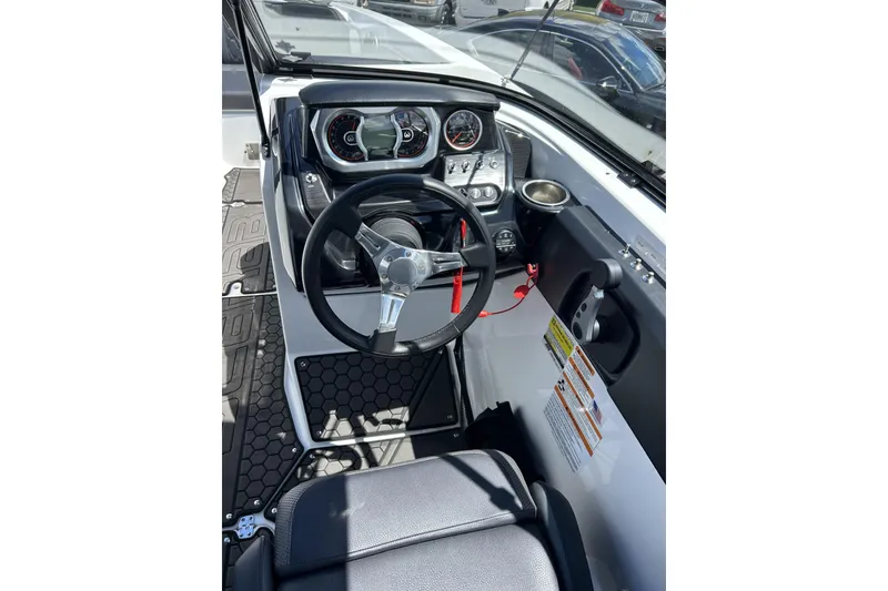 Slide: The Image of 2023 Scarab 255 ID boat cockpit with steering wheel and dashboard controls. - 13