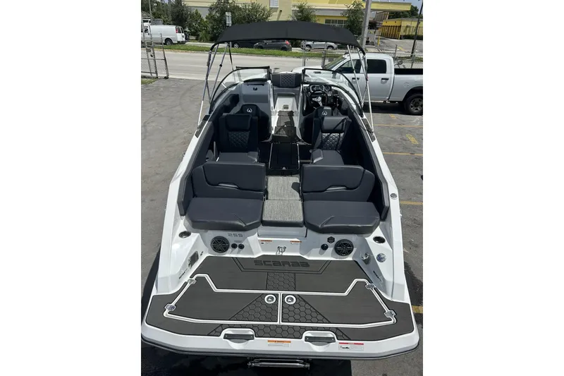 Slide: The Image of 2023 Scarab 255 ID boat with sleek seating and modern design in a parking lot. - 34