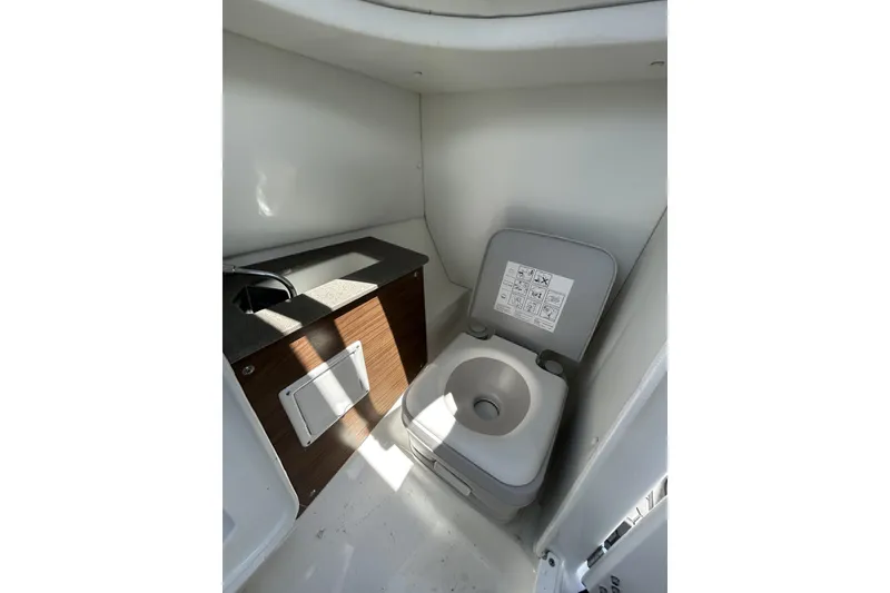 Slide: The Image of 2023 Scarab 255 ID boat interior with compact toilet and sink area. - 39