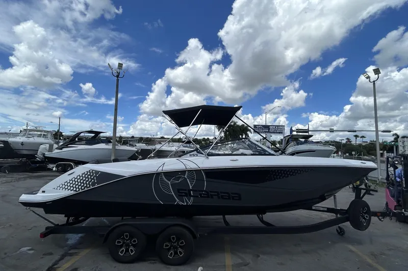 Slide: The Image of 2023 Scarab 255 ID boat on trailer under blue sky with clouds. - 46