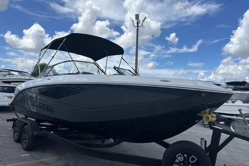 Slide: The Image of 2023 Scarab 255 ID boat on trailer under blue sky with clouds. - 47