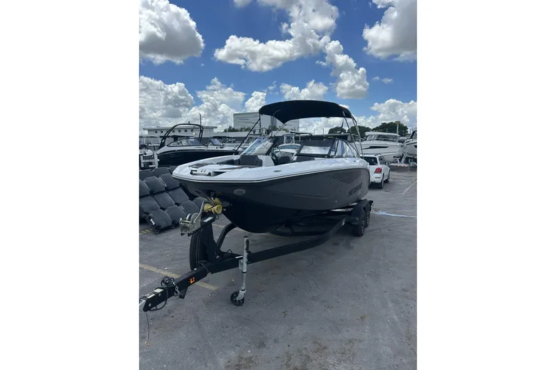Slide: The Image of 2023 Scarab 255 ID boat on trailer under cloudy sky at marina. - 50