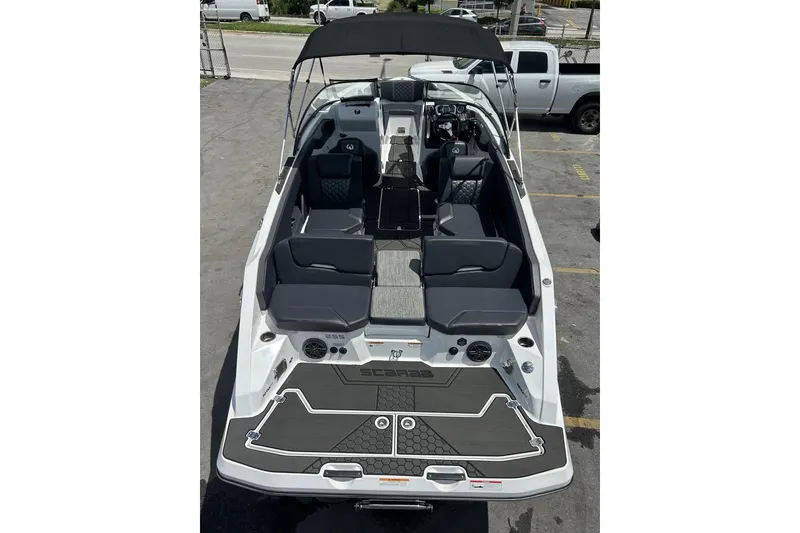 Slide: The Image of 2023 Scarab 255 ID boat with sleek seating and modern design in a parking lot. - 58