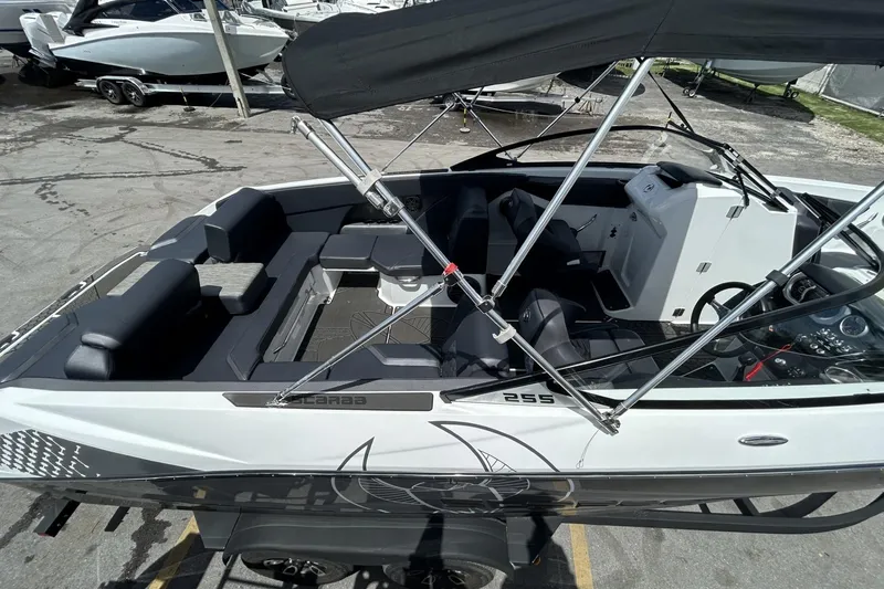 Slide: The Image of 2023 Scarab 255 ID boat with sleek interior and canopy, docked at marina. - 60