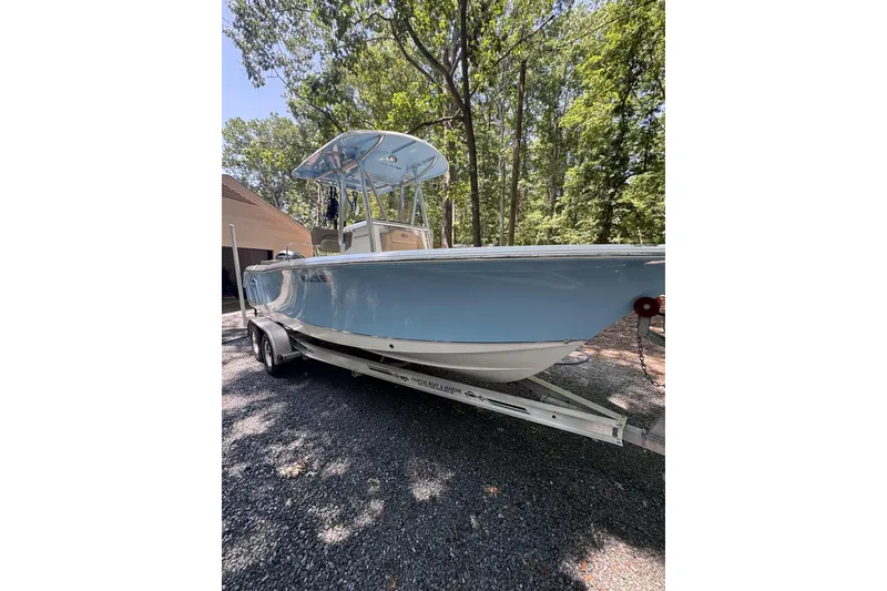 Slide: The Image of 2018 Sea Hunt Ultra 234 boat on calm water with scenic background. - 0