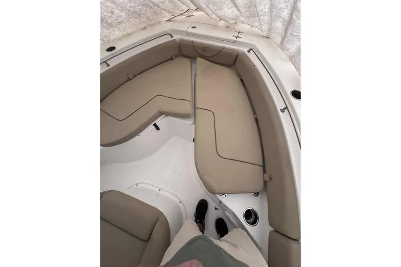 Slide: The Image of 2018 Sea Hunt Ultra 234 boat on calm water with trees in the background. - 11