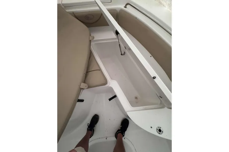 Slide: The Image of 2018 Sea Hunt Ultra 234 boat on calm water, surrounded by lush greenery. - 12