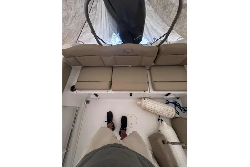 Slide: The Image of 2018 Sea Hunt Ultra 234 boat on calm water with trees in the background. - 13