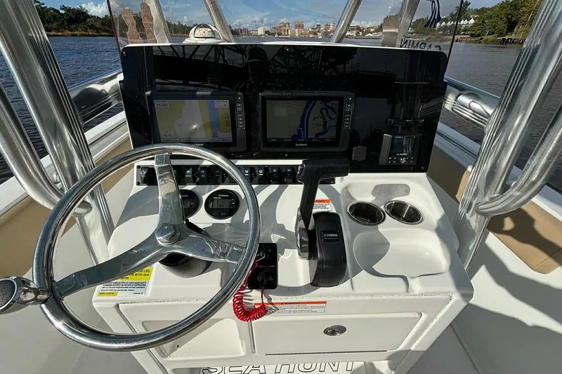 Slide: The Image of 2018 Sea Hunt Ultra 234 boat console with steering wheel and navigation screens. - 16