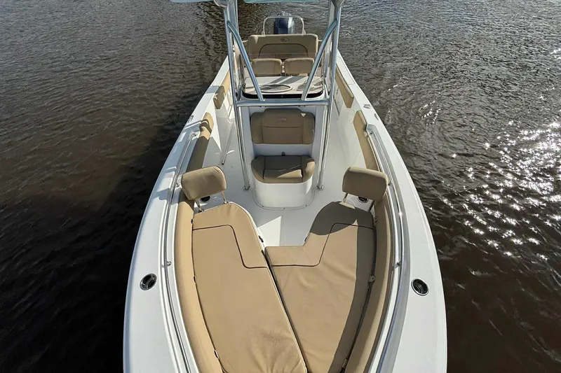 Slide: The Image of 2018 Sea Hunt Ultra 234 boat with tan seating on calm water. - 17