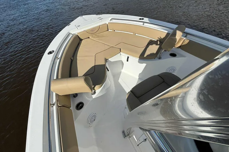 Slide: The Image of 2018 Sea Hunt Ultra 234 boat with tan seating, docked on calm water. - 18