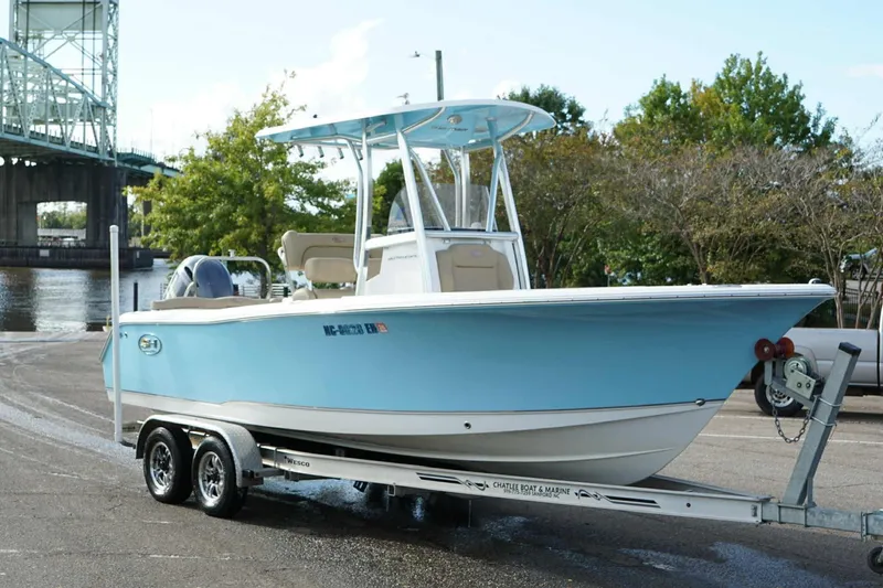 Slide: The Image of 2018 Sea Hunt Ultra 234 boat on trailer near waterfront and bridge. - 25