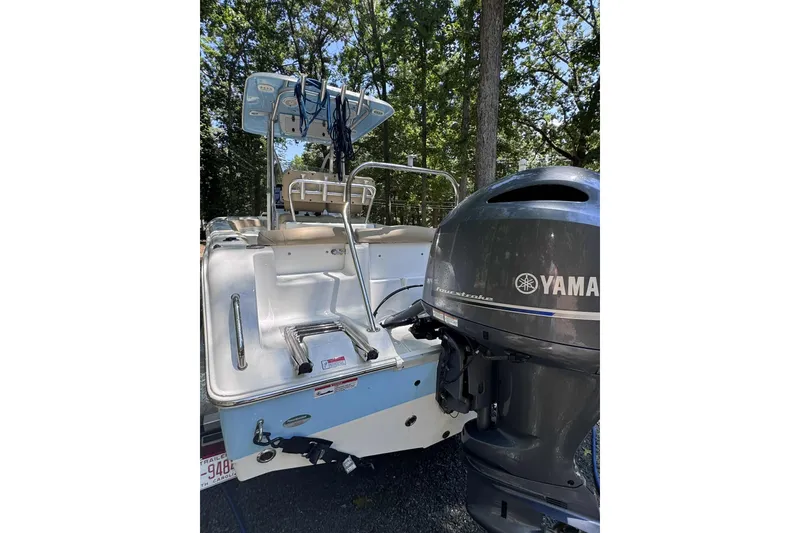 Slide: The Image of 2018 Sea Hunt Ultra 234 boat on a calm river with lush green trees. - 4