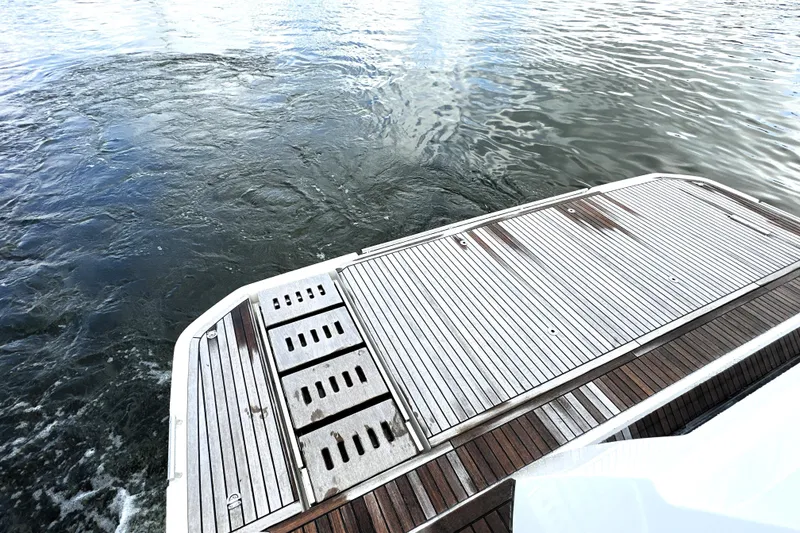 Slide: The Image of 2023 Prestige 520 yacht's wooden deck by the water, showcasing luxury design. - 11