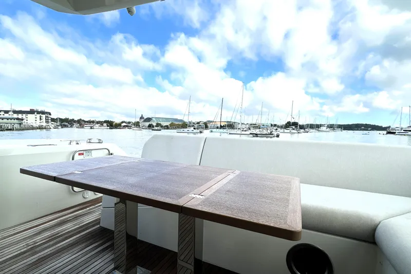 Slide: The Image of Luxury yacht deck view with table, Prestige 520, 2023 model, overlooking marina and blue sky. - 13