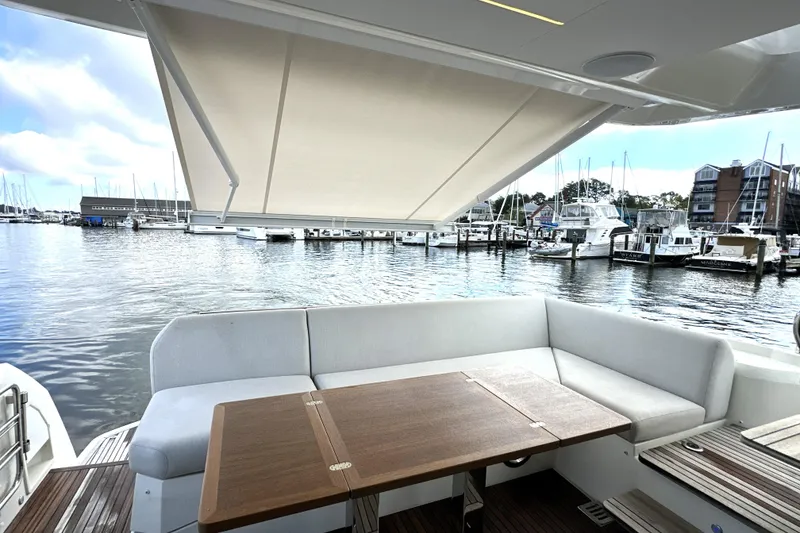 Slide: The Image of 2023 Prestige 520 yacht with shaded seating area overlooking marina. - 15