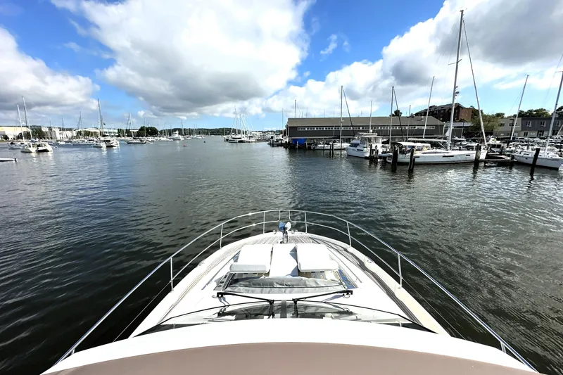 Slide: The Image of Prestige 520 yacht in marina, 2023 model, surrounded by sailboats under a partly cloudy sky. - 16