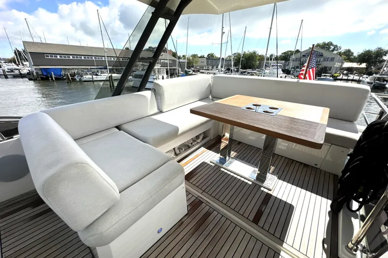 Slide: The Image of Luxurious seating area on 2023 Prestige 520 yacht with wooden table and marina view. - 19