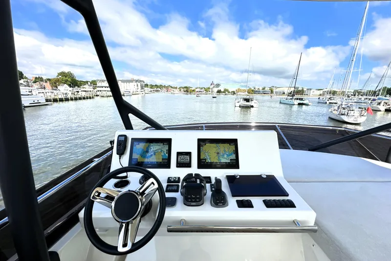 Slide: The Image of Cockpit view of 2023 Prestige 520 yacht with navigation screens and steering wheel. - 27