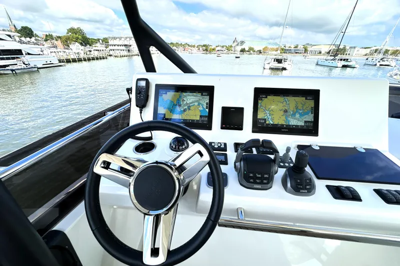 Slide: The Image of Modern helm of 2023 Prestige 520 yacht with navigation screens and controls, docked in marina. - 29