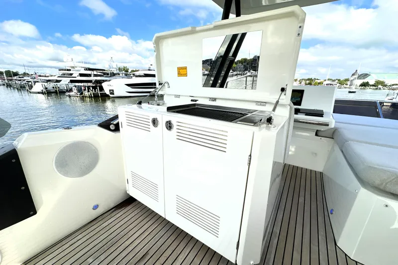 Slide: The Image of Outdoor kitchen on 2023 Prestige 520 yacht, featuring grill and storage, docked at marina. - 31