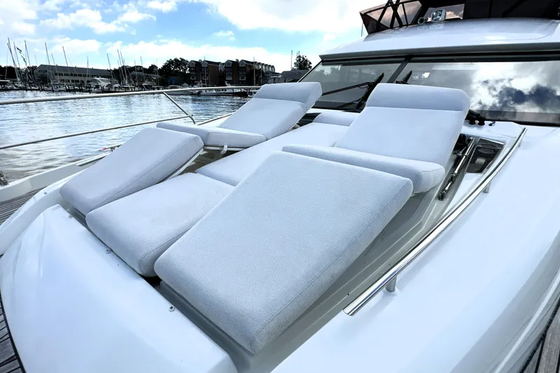 Slide: The Image of 2023 Prestige 520 yacht with luxurious sun loungers on deck, docked at marina. - 36